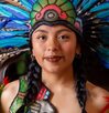 Bailarina con traje azteca y un penacho de colores.