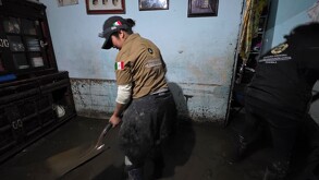 Personal de Protección Civil apoyando en labores de desasolve debido a una inundación.