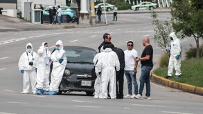 Peritos platicando con personas junto a un vehículo, en la Vía Atlixcáyotl de Puebla.