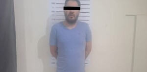 Se observa un hombre con playera azul y con cintilla negra en ojos.