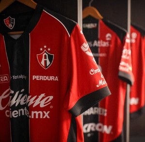 Playeras de los jugadores del Atlas FC colgadas en ganchos dentro de los vestidores del equipo en el Estadio Jalisco