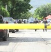 Se observa una cintilla amarilla de precaución y una camioneta blanca de fondo.