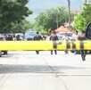 Se observa una cintilla amarilla de precaución y una camioneta blanca de fondo.