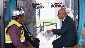 Hombres sentados al interior de una cabina de cablebús.
