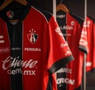 Playeras de los jugadores del Atlas FC colgadas en ganchos dentro de los vestidores del equipo en el Estadio Jalisco