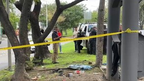 Área acordonada debajo de puente peatonal con policías y patrulla de Guadalajara resguardando la zona con árboles y áreas verdes alrededorq