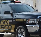 Vista del costado de una patrulla de la Policía del Estado de Jalisco estacionada al exterior de una viviendas con fachada color blanco