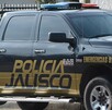 Vista del costado de una patrulla de la Policía del Estado de Jalisco estacionada al exterior de una viviendas con fachada color blanco