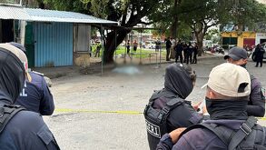 Policía resguarda zona del crimen donde una mujer fue asesinada.