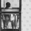 Vista de espaldas a una mujer sentada en una mesa de madera.