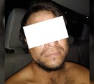 Hombre sin playera y con los ojos censurados por un rectángulo blanco dentro de una patrulla de la Policía de Guadalajara