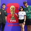 Dos hombres y una mujer delante de un cartel promocional del Fan Fest del Mundial en Guadalajara