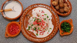 Chile en nogada servido en un plato tradicional de Puebla junto con todos sus aditamentos.