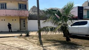 Elemento de la policía resguarda una casa por el hallazgo de restos humanos.