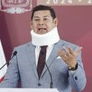 Hombre con collarín hablando ante un micrófono.