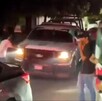 Patrulla de la Policía Municipal de Apatzingán siendo rodeada y empujada por fanáticos con playeras de la Selección Mexicana