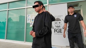 un hombre detenido custodiado por dos policías