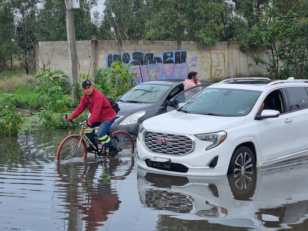Ciclista atrapado en una calle inundada de Puebla.