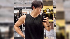 Creador de contenido Jason Coreano tomándose una selfie con su celular delante de un espejo en un gimnasio