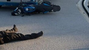 Piernas con pantalón negro junto a moto negra