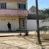 Elemento de la policía resguarda una casa por el hallazgo de restos humanos.