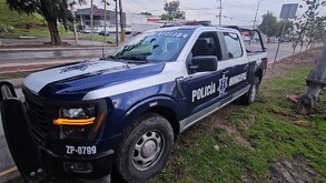 Patrulla de la Policía Municipal de Zapopan orillada sobre un camino de tierra a un costado de Perifério Sur