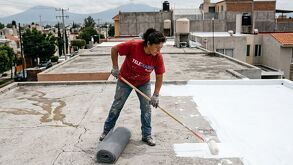 persona pone impermeabilizante blanco en su techo