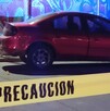 Automóvil color rojo estacionado en la calle al lado de una pared con un grafitti y una cinta policiaca acordonando el sitio