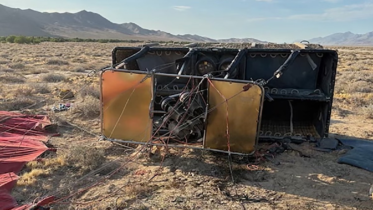 Vista de la parte superior de un globo aerostático volcado en medio de un desierto tras haberse incendiado