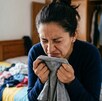 Persona huele con asco una playera seca después de lavarla