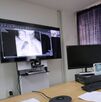 Un hombre frente a una pantalla viendo una radiografía