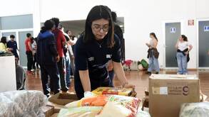 Una joven voluntaria del Centro de Acopio UNAM frente a cajas de alimentos y artículos de primera necesidad