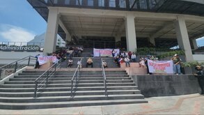 un grupo de personas se manifiestan en el edificio de planeación y finanzas en puebla