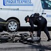 Mujer oficial de la Policía de Tlajomulco acercándose a una motocicleta tumbada sobre el asfalto tras un accidente automovilístico