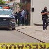 Patrulla y oficiales de la Policía de Colima en un área acordonada por una cinta policiaca tras un ataque a balazos en un autolavado
