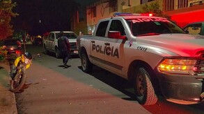 Patrulla de la Policía Municipal de Tlaquepaque estacionada en medio de la calle con una moto amarilla al lado y policías caminando detrás