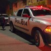 Patrulla de la Policía Municipal de Tlaquepaque estacionada en medio de la calle con una moto amarilla al lado y policías caminando detrás