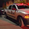Patrulla de la Policía Municipal de Tlaquepaque estacionada en medio de la calle con una moto amarilla al lado y policías caminando detrás