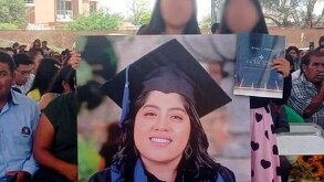 Mujeres sosteniendo la fotografía de una mujer presa.