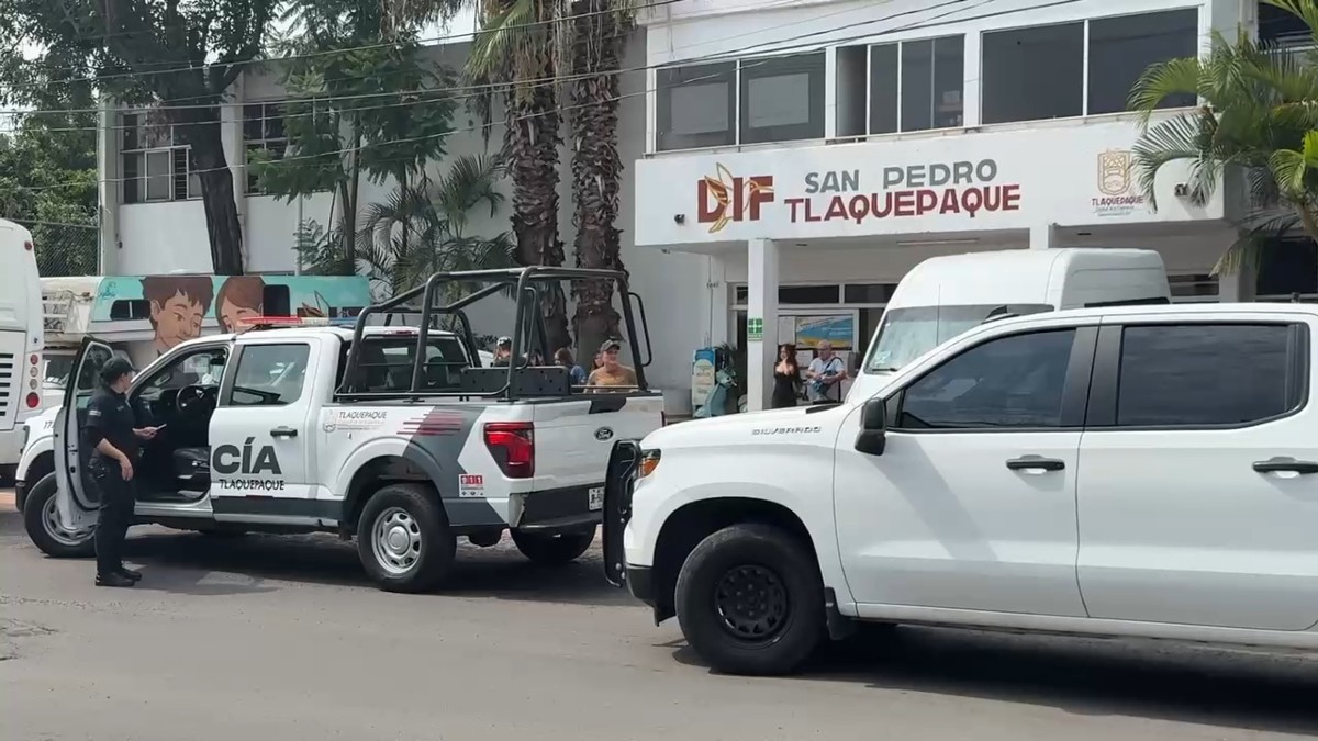 Una oficial y patrulla de la Policía de Tlaquepaque estacionada al exterior de un centro médico del DIF en Tlaquepaque