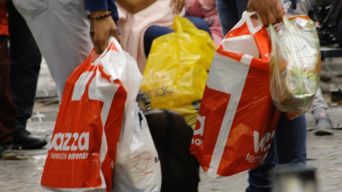 Personas poblanas con bolsas de plástico caminan por las calles
