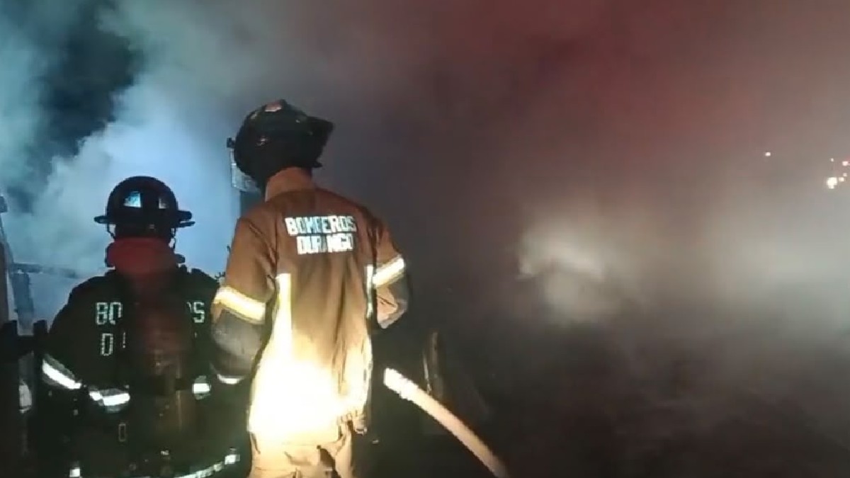 Bomberos en un incendio y al lado de humo