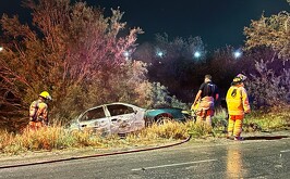 Bomberos apagando el incendio de un automóvil en el cruce Esterito-Mieleras.