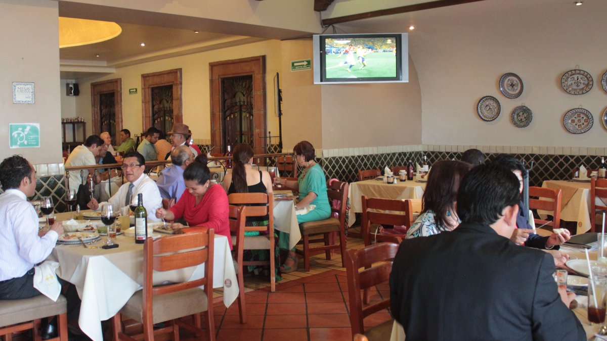 Familias ven el partido del mundial en pantalla de restaurante