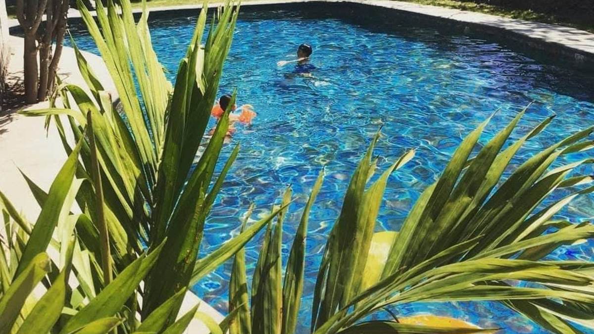 Personas nadan dentro de las piscinas de las aguas termales del parque acuático