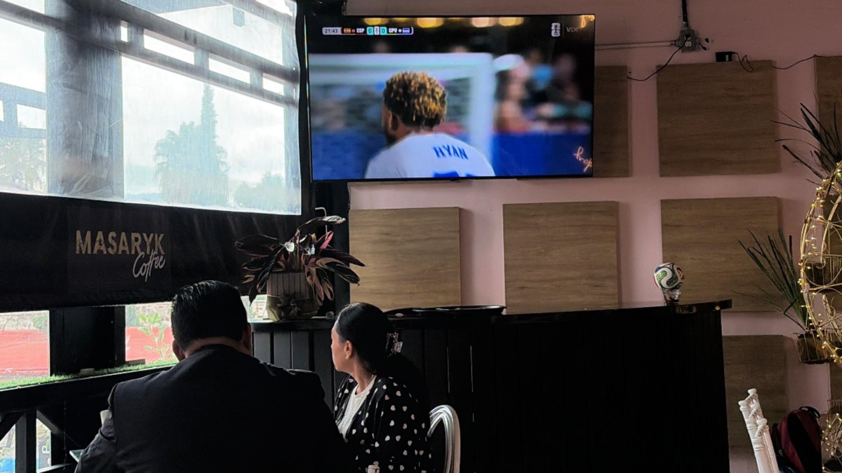 Personas ven un partido del Mundial en el restaurante mientras consumen alimentos