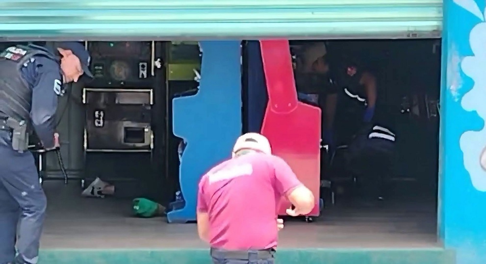 Cadáver de un hombre tendido en un negocio de videojuegos.