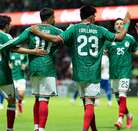 Jugadores de la selección mexicana abrazados en la cancha vistos por la espalda