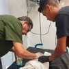 Se observa a dos hombres, los dos están mirando a un bebé acostado y tapado con una cobija.