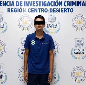 Se observa un hombre que viste pantalón de mezclilla y playera; tiene tapados los ojos.